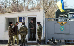Ukrainian pilots and soldiers gather at the air base entrance in Fedorovka, Saky district, Crimea, on March 22, 2014.