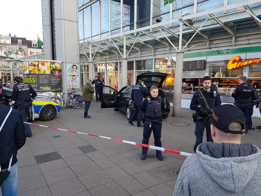 Police officers guarding a car in front of the building in Heidelberg where the man drove into pedestrians.