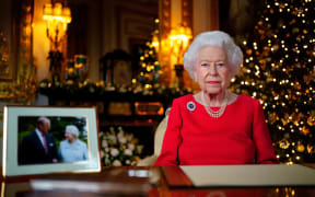 Queen Elizabeth II during her annual Christmas Day message, with a photograph of herself and her late husband Prince Philip, Duke of Edinburgh, in the White Drawing Room Windsor Castle on December 23, 2021.