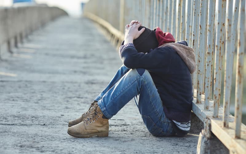 young homeless boy sleeping on the bridge, poverty, city, street