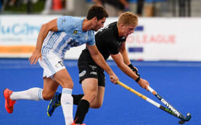 Sam Lane of the Black Sticks battles with Jose Tolini of Argentina for possession.