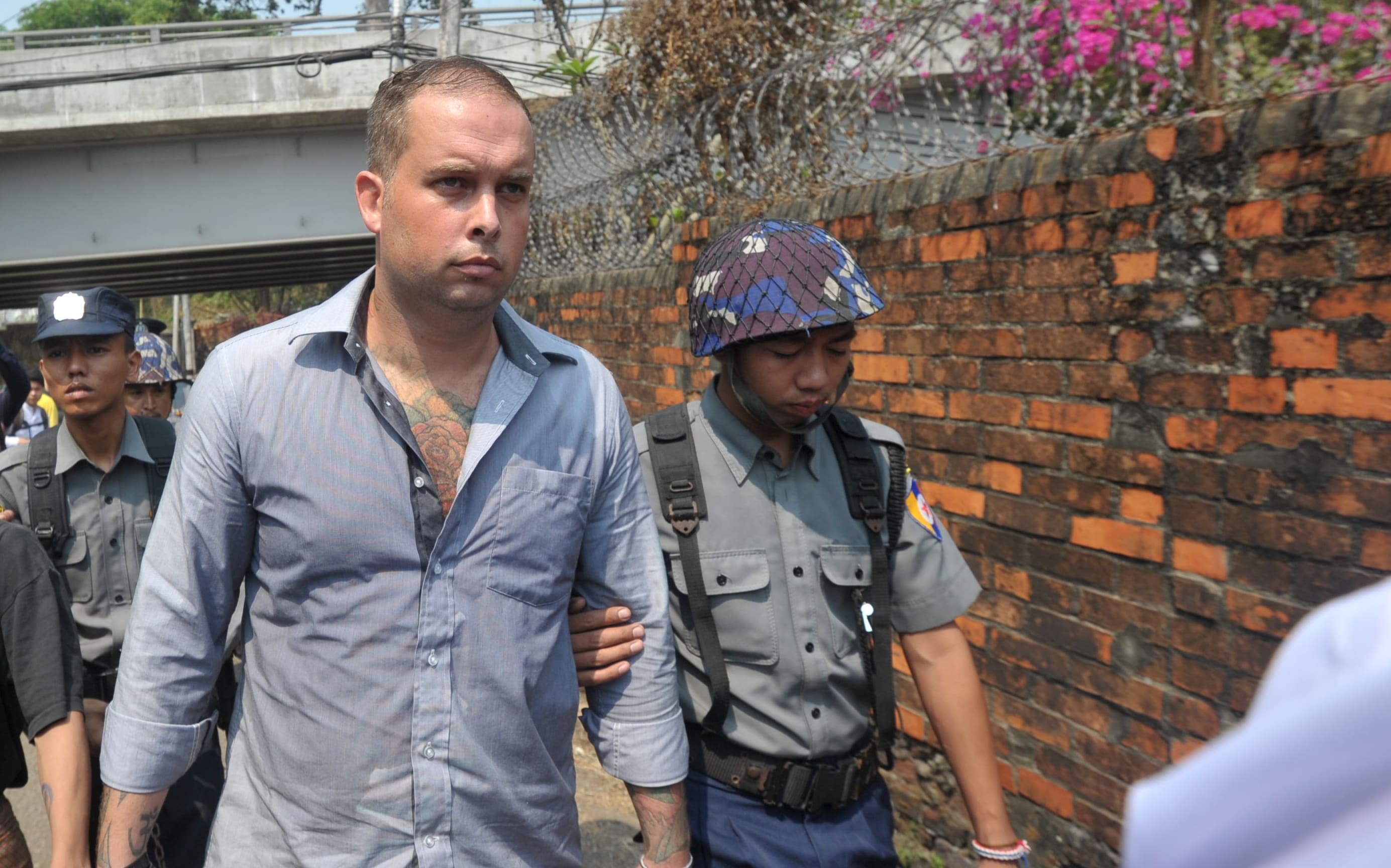 New Zealand bar manager Philip Blackwood, centre, is escorted by police as he arrives at a court for a hearing in Yangon on 17 March 2015.