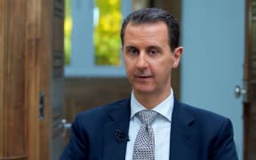 A handout picture released by the Syrian presidency's press office shows Syrian President Bashar al-Assad during an interview with AFP in the capital Damascus, on April 12, 2017.