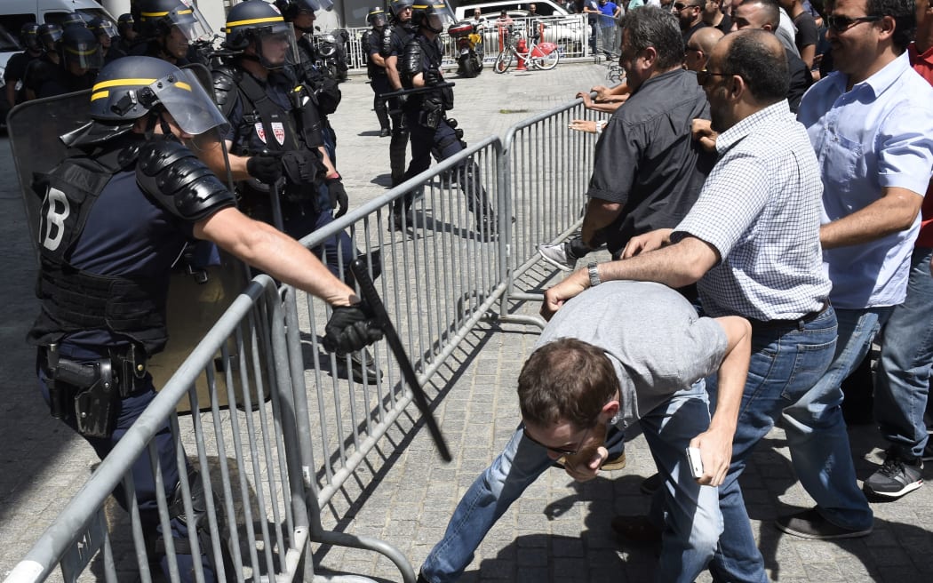 French CRS riot police clash with taxi drivers blocking the entrance of the Oxygene tower which hosts UberPOP local headquarters.