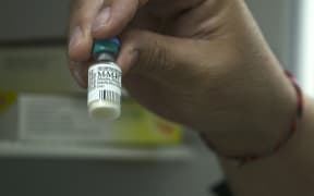 Dr Richard Hulme holding Measles Vaccine