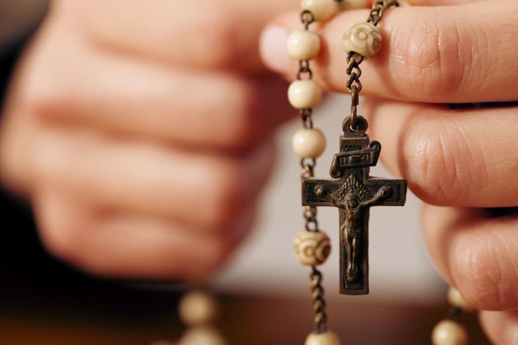 hands holding rosary beads