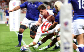 Japan's openside flanker Pieter Labuschagne (2L) stretches to ground the ball to score Japan's first try during the France 2023 Rugby World Cup Pool D match between Japan and Samoa at the Stadium de Toulouse in Toulouse, southwestern France on September 28, 2023. (Photo by CHARLY TRIBALLEAU / AFP)