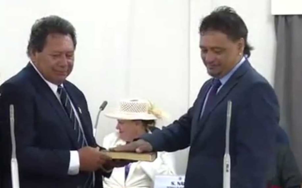 In this screenshot from the Parliament live  stream, Albert Nicholas (right) is sworn in as a member of the Cook Islands Parliament on 9 April 2019.