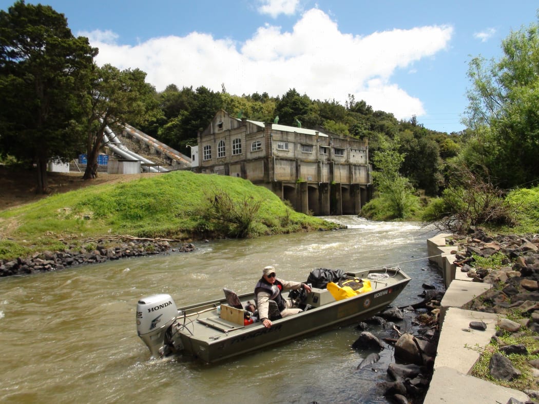 Millan Ruka on his boat with the Wairua power station in background.