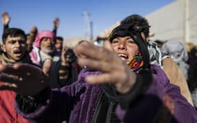 People protest in front of Adra Prison demanding the release of their family members, in Syria's town of Adra on the northeastern outskirts of Damascus on 25 December, 2024.