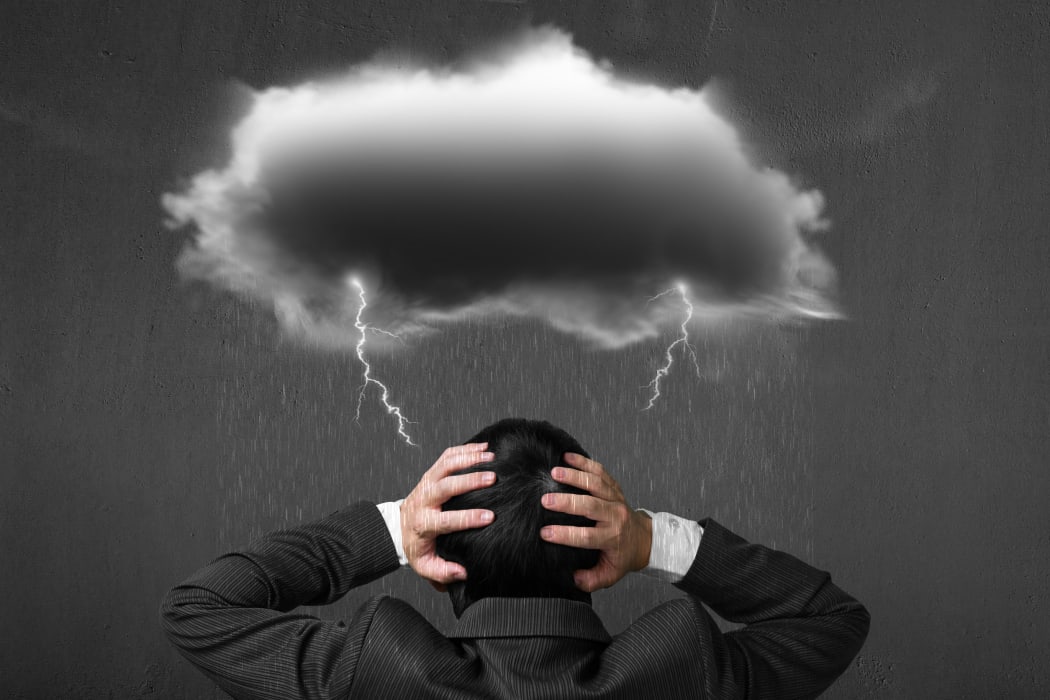 Depressed man with dark cloud rain lightning over his head.