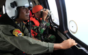 Indonesian crew members observe the surface of the sea during the search for AirAsia Flight QZ8501.