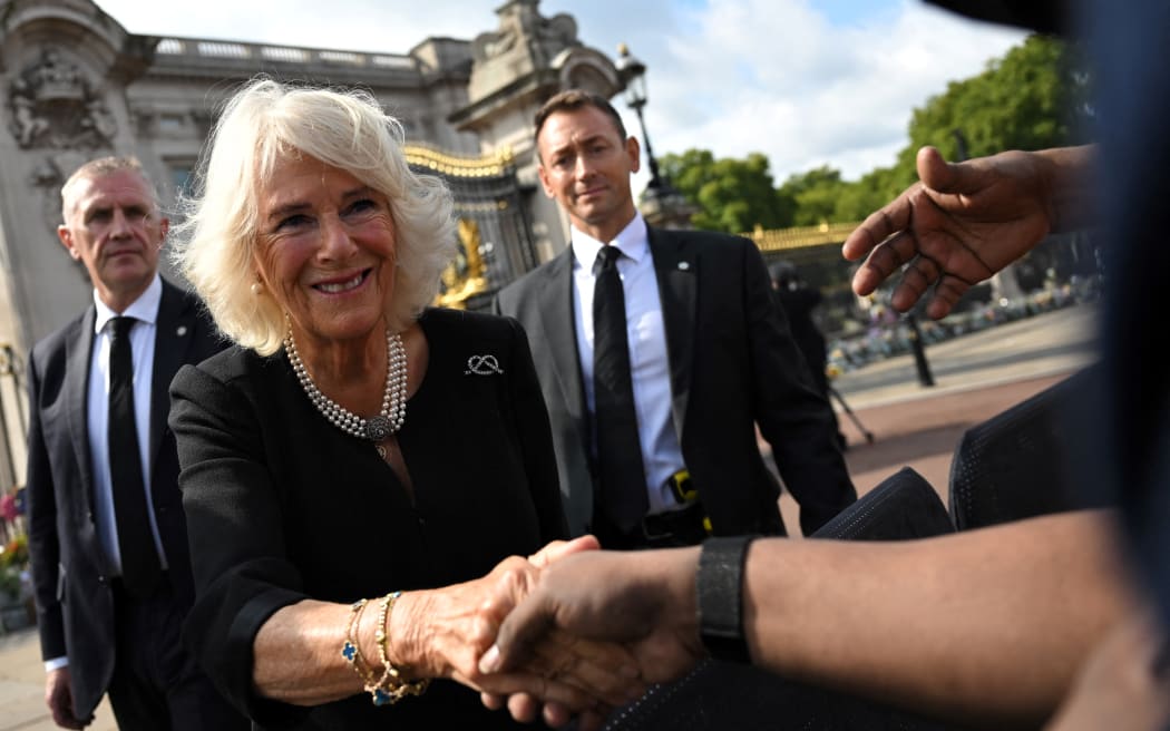 Camilla, Queen Consort, greets the members of the public in the crowd upon her arrival at Buckingham Palace in London, a day after Queen Elizabeth II died.