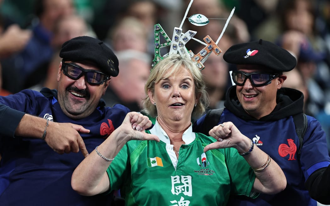 Spectators in France's team attire and Ireland's team colours cheer in the stands ahead of the France 2023 Rugby World Cup quarter-final match between Ireland and New Zealand at the Stade de France in Saint-Denis, on the outskirts of Paris, on October 14, 2023.