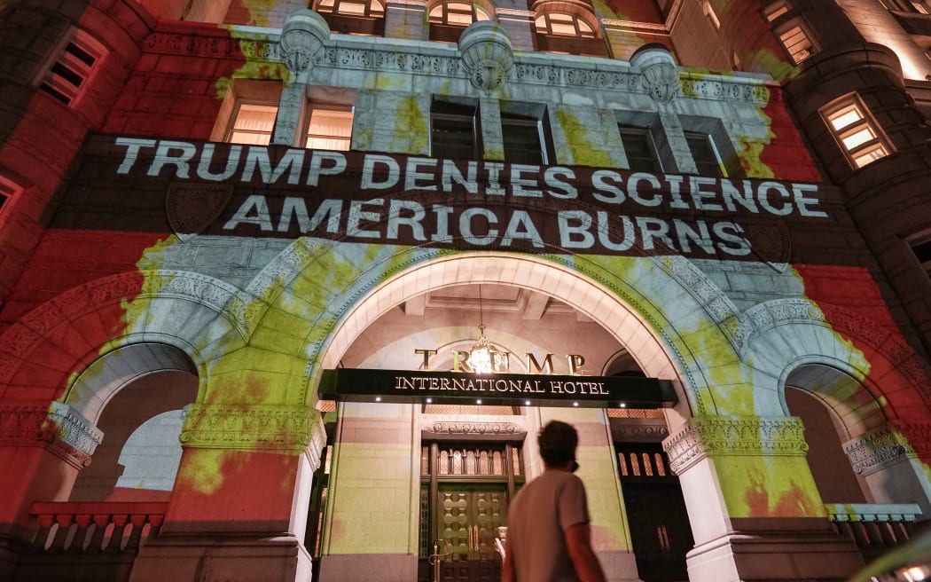 Activists project flames and commentary on the side of the Trump International Hotel in protest of President Donald Trump's response to science and climate change.