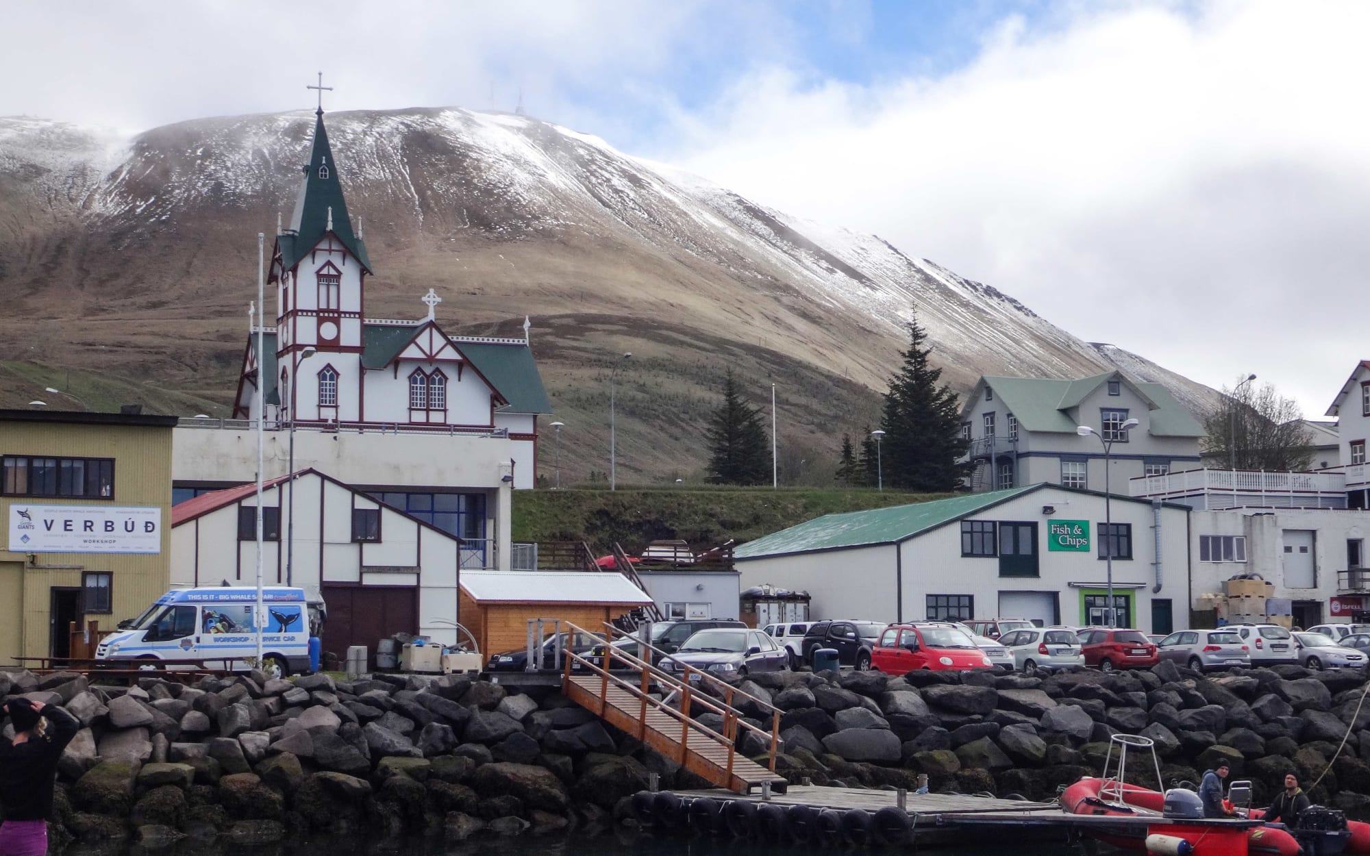 Icelandic town with church and hill dusted with snow.