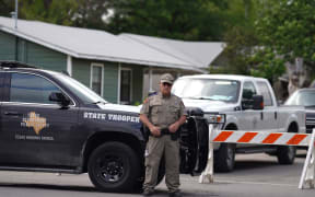 A State trooper stands seen outside of Robb Elementary School in Uvalde, Texas, on May 24, 2022. - An 18-year-old gunman killed 14 children and a teacher at an elementary school in Texas on Tuesday, according to the state's governor, in the nation's deadliest school shooting in years. (Photo by allison dinner / AFP)