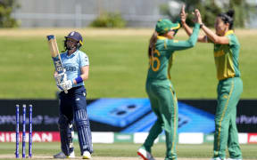 South Africa's Marizanne Kapp (R) celebrates the wicket of England's Heather Knight (L) with a teammate during 2022 Women's Cricket World Cup match between England and South Africa at Bay Oval in Tauranga on March 14, 2022.