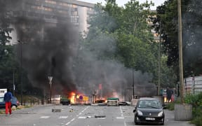 Smoke rises from a bonfire in a residential area during clashes in Toulouse, southwestern France on June 28, 2023, a day after the killing of a 17 year old boy in Nanterre by a police officer's gunshot following a refusal to comply. France braced for more angry protests on June 28, 2023 after the killing of a teenager by police during a traffic stop that President Emmanuel Macron called "unforgivable". (Photo by Lionel BONAVENTURE / AFP)