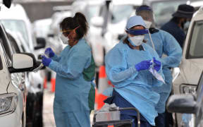 Health workers conduct PCR tests at the St Vincent's Bondi Beach COVID-19 drive through testing clinic on December 22, 2021 in Sydney, as the number of COVID-19 cases keeps on the rise