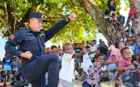 Local kids learning Chinese Kungfu from a member of the China Police Liaison Team.