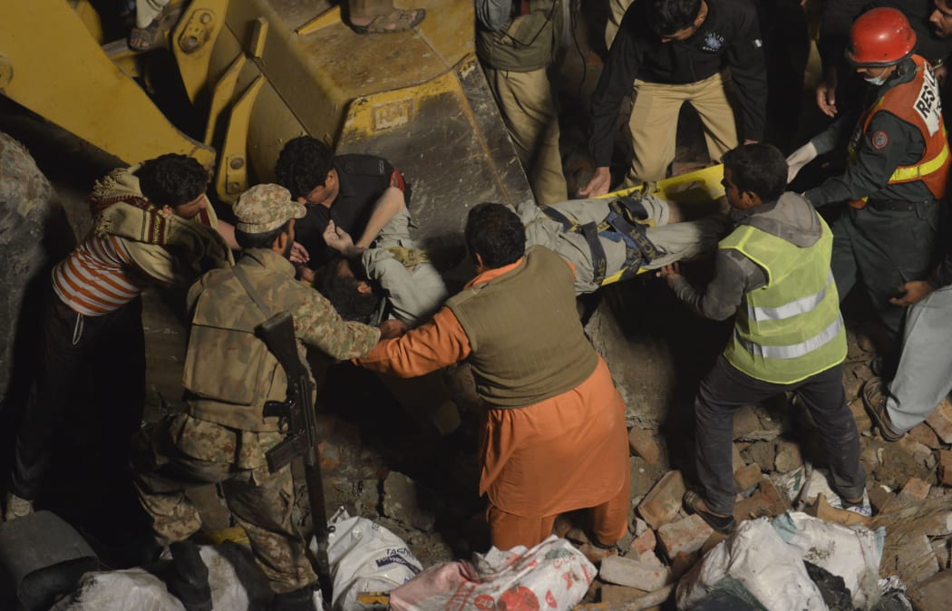 A person is carried from the debris after a factory collapsed in Lahore