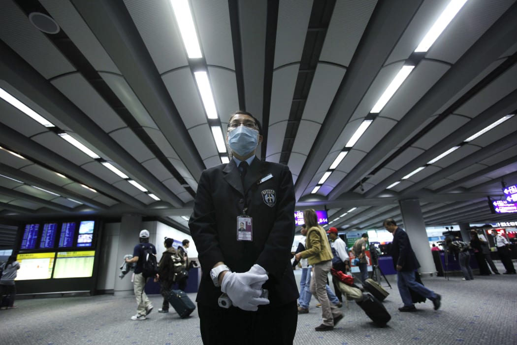 A health worker stands by ready for temperature screening of travellers on April 27, 2009 at the international airport in Hong Kong.