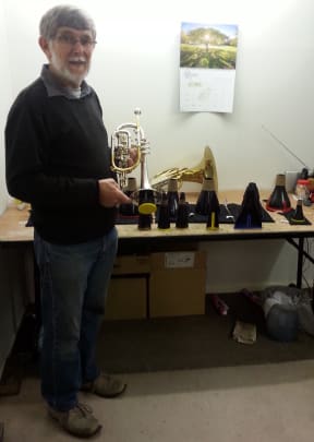 A photo of Trevor Bremner with a table full of mutes