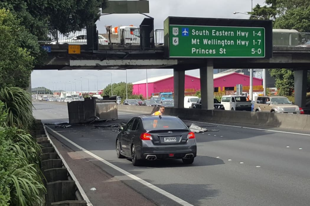 The truck flipped onto its side after hitting the Penrose overbridge on Auckland's Southern motorway.