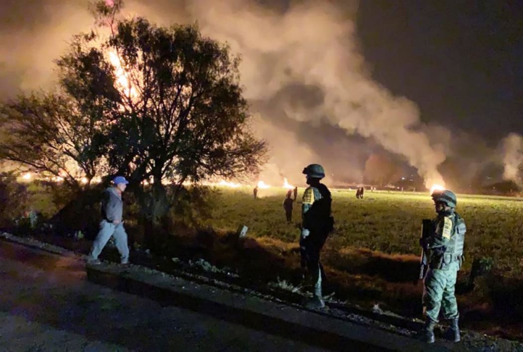 Mexican soldiers standing guard near a fire after a leaking gas pipeline triggered a blaze in Tlahuelilpan, Hidalgo state, on January 18, 2019.