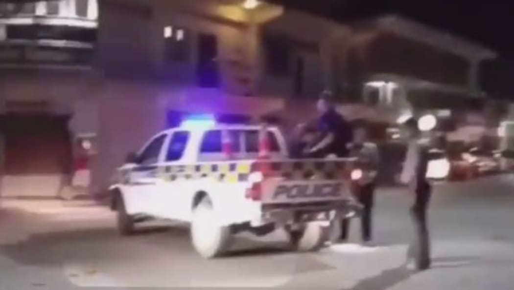The man in the back of the truck with the police officer in Tonga