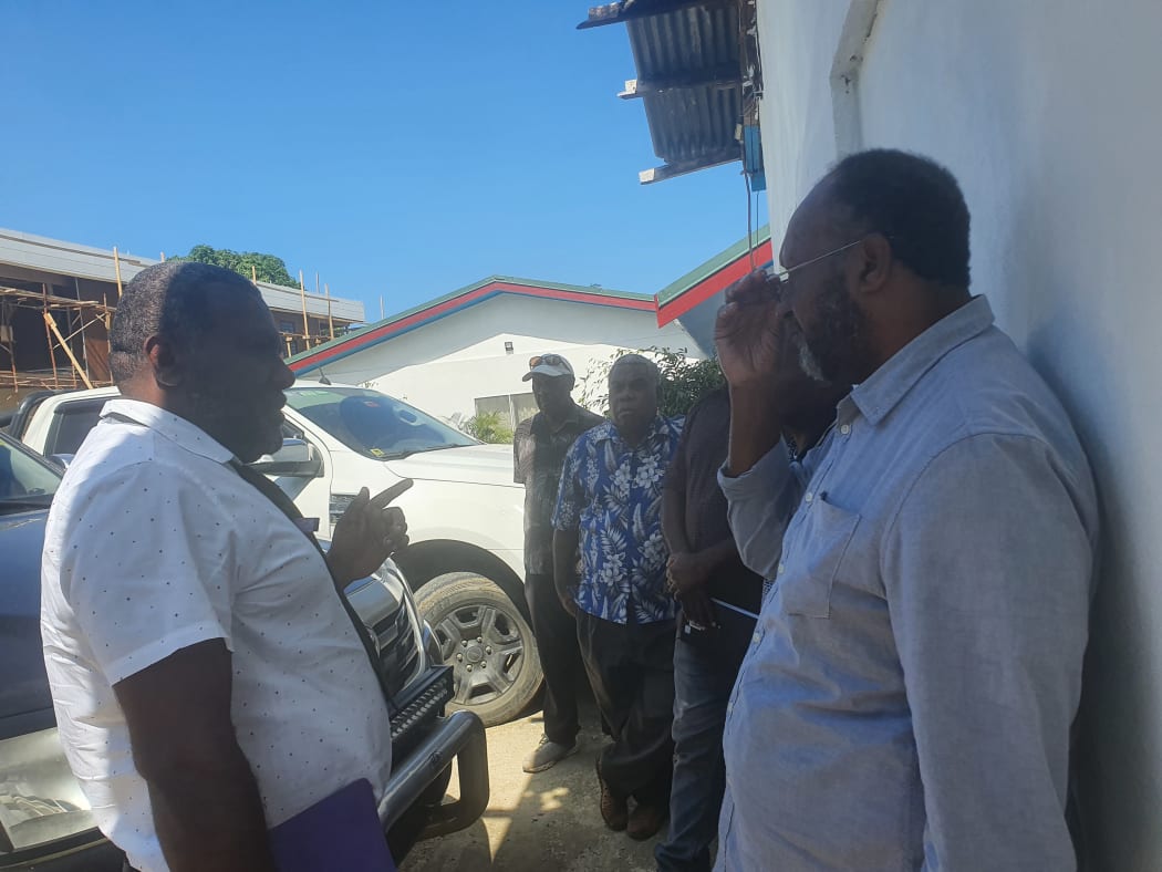 Charlot Salwai, (right), talks with his lawyer outside court