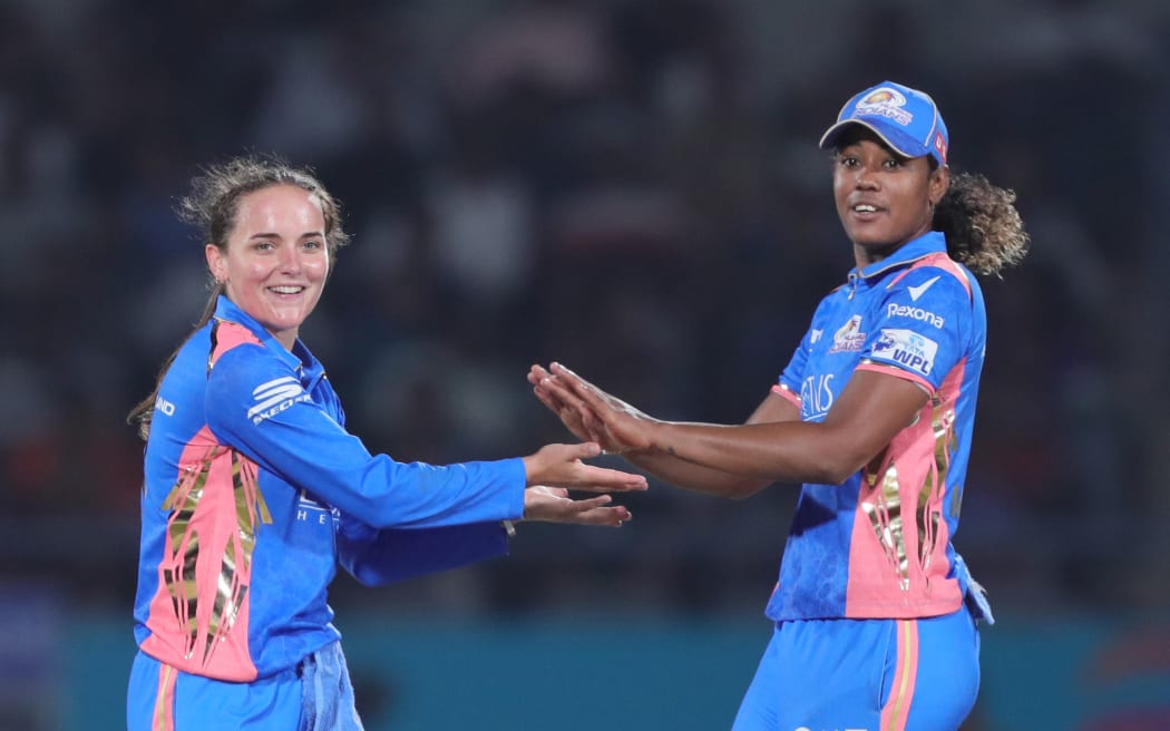 Melie Kerr (L) and Hayley Matthews of the Mumbai Indians celebrate a wicket.