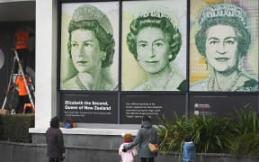 Passersby inspect Queen tribute window at Reserve Bank