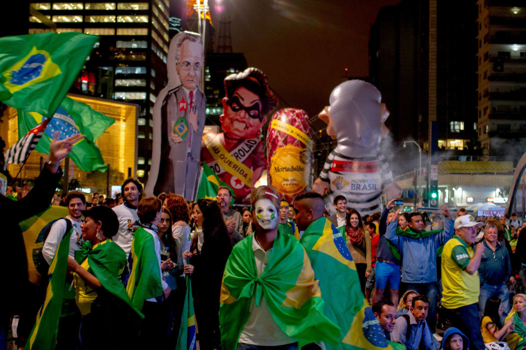 Demonstrators carry giant dummies that represent Brazilian President Dilma Rousseff (L) and Brazilian former President Luiz Inacio Lula da Silva during a protest.