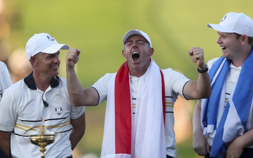 FARMINGDALE, NEW YORK - SEPTEMBER 28: Captain Luke Donald, Rory McIlroy and Robert MacIntyre of Team Europe are seen at the trophy ceremony after Team Europe defeated Team United States 15-13 during the Sunday singles matches of the 2025 Ryder Cup at Black Course at Bethpage State Park Golf Course on September 28, 2025 in Farmingdale, New York.   Carl Recine/Getty Images/AFP (Photo by Carl Recine / GETTY IMAGES NORTH AMERICA / Getty Images via AFP)