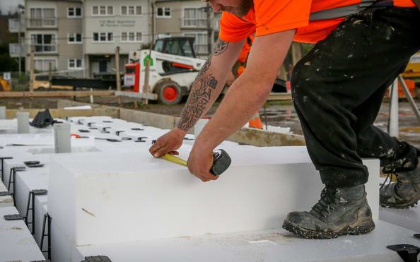 A builder installing polystyrene used for insulation and foundation footings on a new home in Upper Hutt.