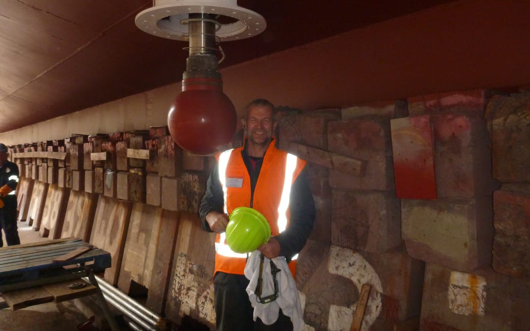 Niwa marine technician Steve Wilcox under the Niwa vessel Tangaroa replacing seafloor-mapping transducers. 