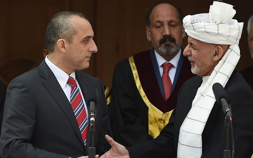 Afghan President Ashraf Ghani (C) shakes hands with his first vice-president Amrullah Saleh (L)  during his swearing-in at the inauguration ceremony as the country's leader