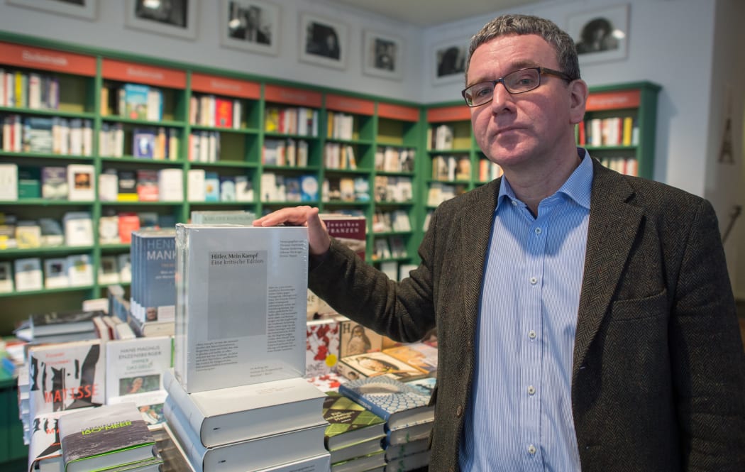 Michael Lemling, manager of the bookstore Lehmkuhl, poses next to a stack of editions of 'Hitler, Mein Kampf - eine kritische Edition' (lit. Hitler, My Struggle - a critical edition) at his bookstore in Munich, Germany.