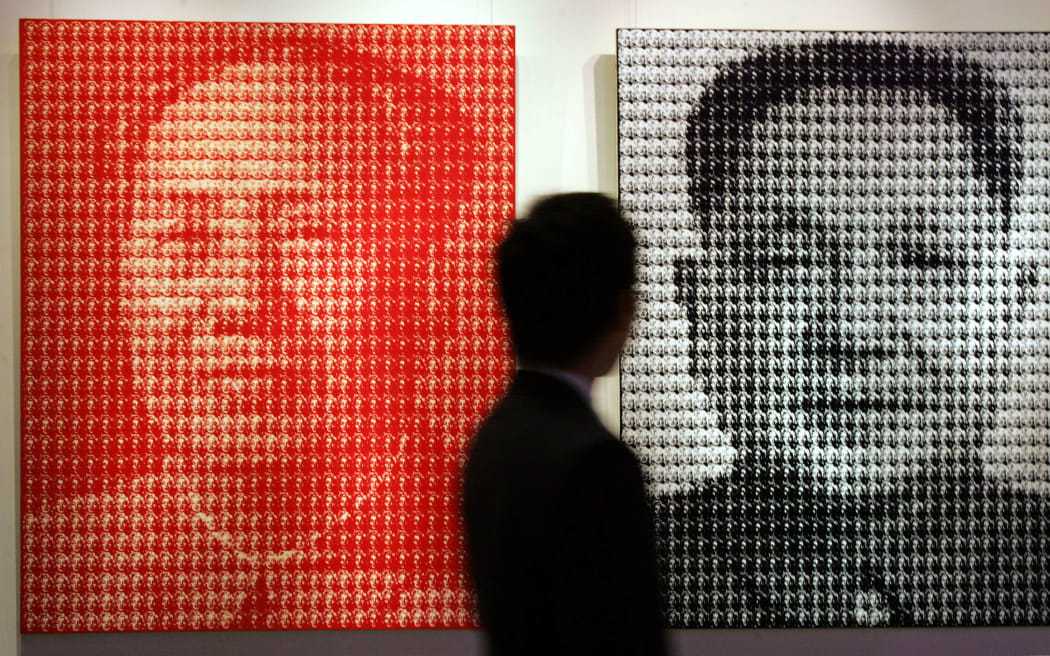 A prospective buyer views two paintings by South Korean artist Kim Dong Yoo entittled "Mao Zedong (L) and Deng Xiaoping (R)" prior to it going under the hammer at Christie's Spring sale, in Hong Kong 27 May 2007.
