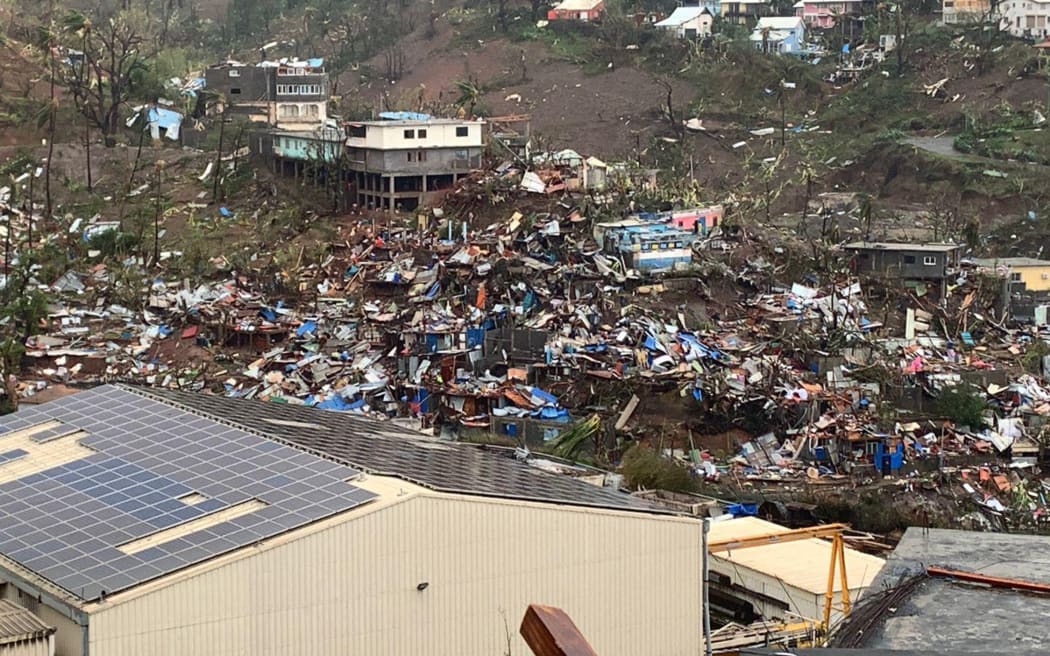 A photo taken on December 15, 2024 shows a pile of debris of metal sheets, wood, furniture and belongings after the cyclone Chido hit France's Indian Ocean territory of Mayotte. - At least 14 people were killed in Mayotte when a fierce cyclone battered the French Indian Ocean territory, authorities said on December 15, 2024, with officials warning it will take days to know the full toll. (Photo by KWEZI / AFP)