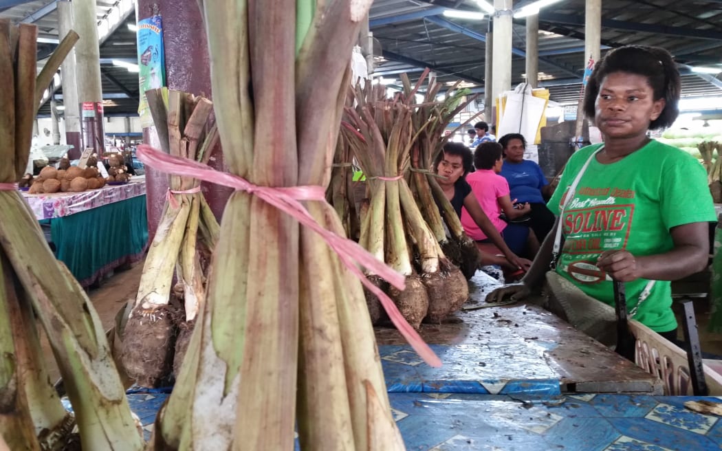 Market vendor with taro crop for sale at the Lautoka Municipal Market, Fiji