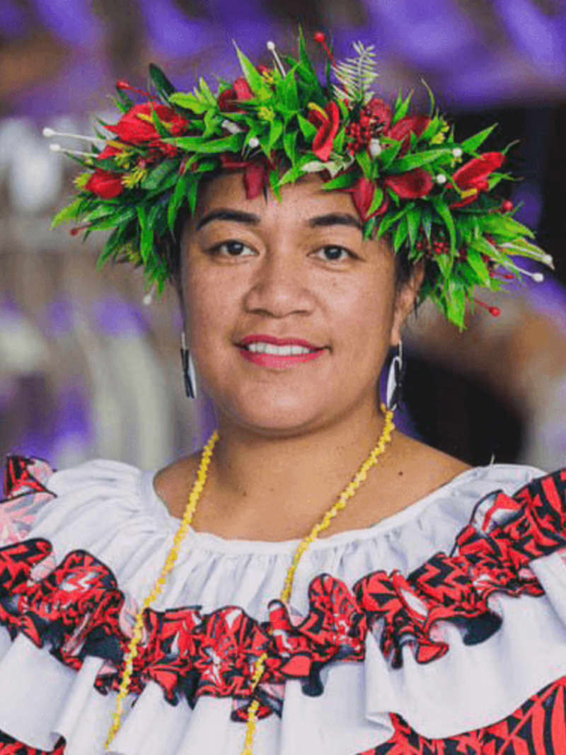 Cora-Allan is a smiling woman in traditional Niuean clothing and headwear.