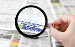 Magnifying glass on job ads.