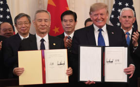 Chinese Vice Premier Liu He and US President Donald Trump display the signed trade agreement between the US and China in the East Room of the White House in Washington, DC, January 15, 2020.