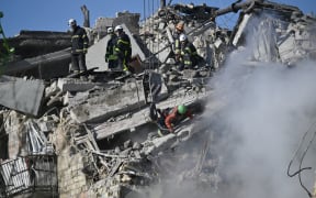 Ukrainian rescuers conduct a search and rescue operation in and around a residential building heavily damaged during a large-scale Russian drone and missile attack on Kyiv on 28 August, 2025.