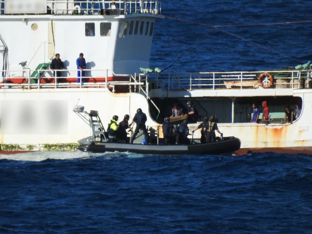 The crew of the Hawea boarding a ship in Fijian waters.