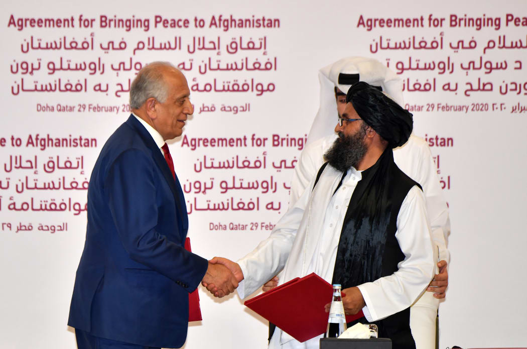 US Special Representative for Afghanistan Reconciliation Zalmay Khalilzad and Taliban co-founder Mullah Abdul Ghani Baradar shake hands after signing a peace agreement during a ceremony in the Qatari capital Doha on February 29, 2020