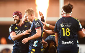 Sam Gilbert (centre) is congratulated after kicking the winning penalty goal for the Highlanders against the Rebels.